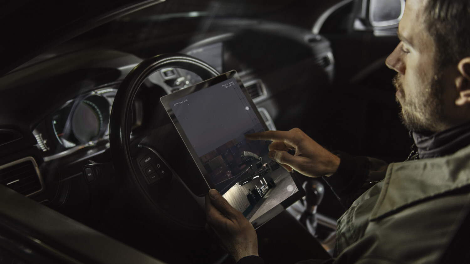 Person in a car with a tablet.