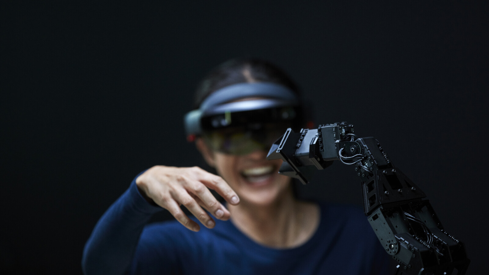 Person with AR glasses inspecting robotic arm.