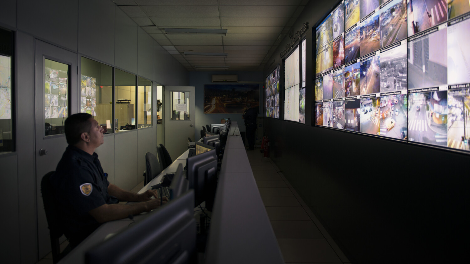 Security person monitoring computer screens.