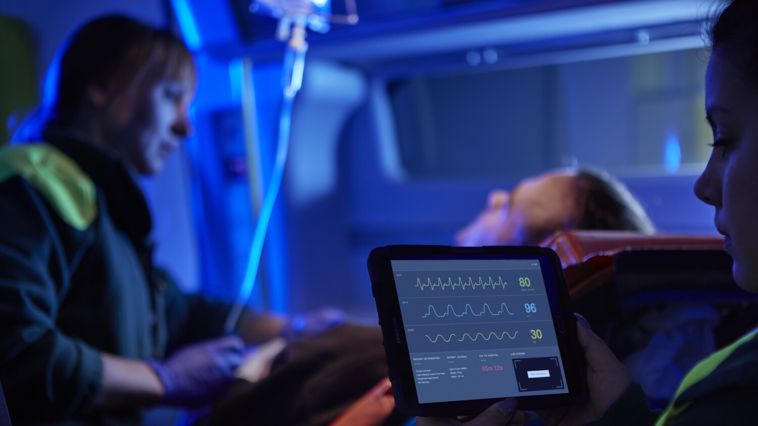 Medical staff with tablet in an ambulance.