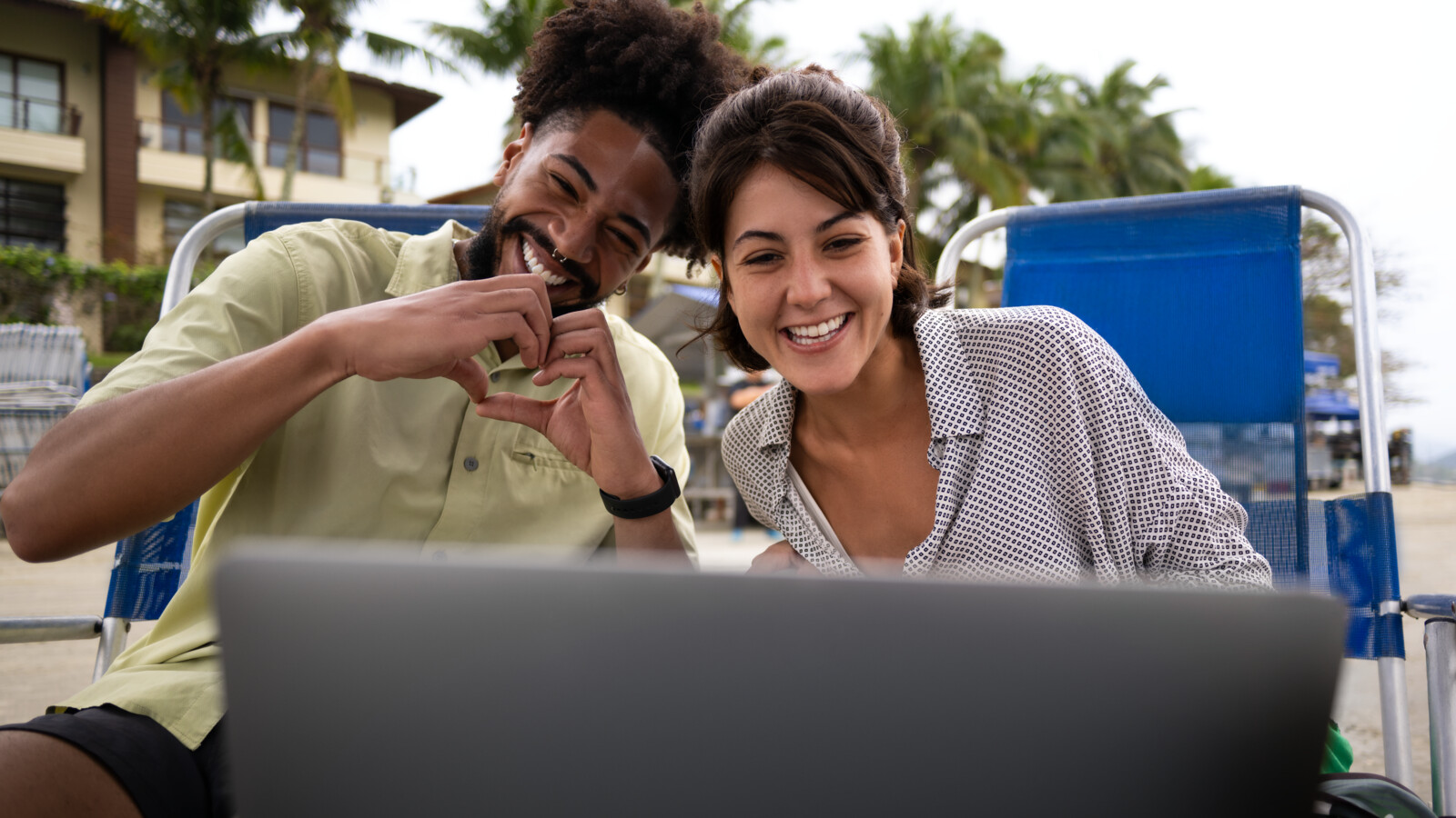 Man and woman smiling and looking at computer.