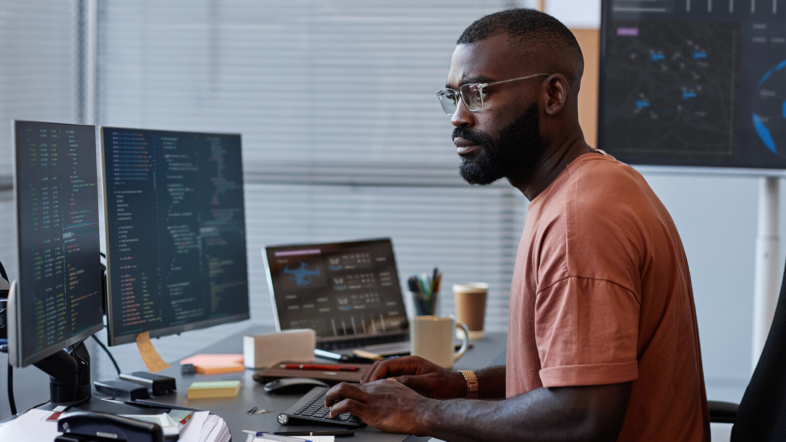 Person at desk with multiple screens.