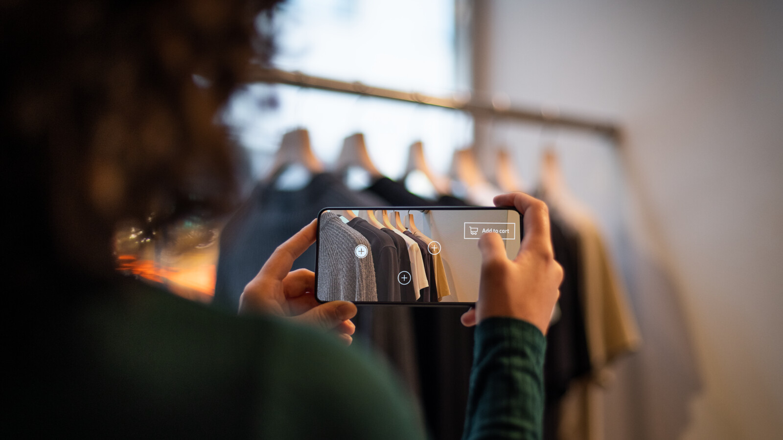 Woman taking a picture of clothes in a store