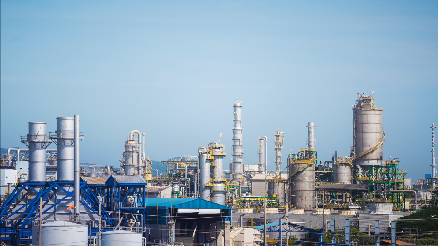 Industrial complex with chimneys, tanks, and machinery.