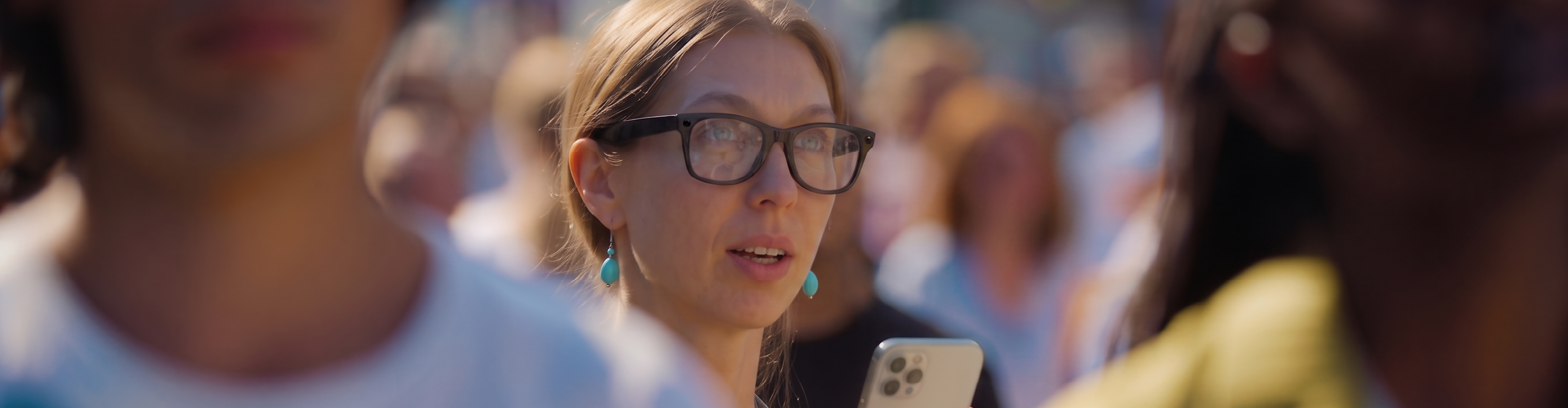 Woman using phone in a crowd 
