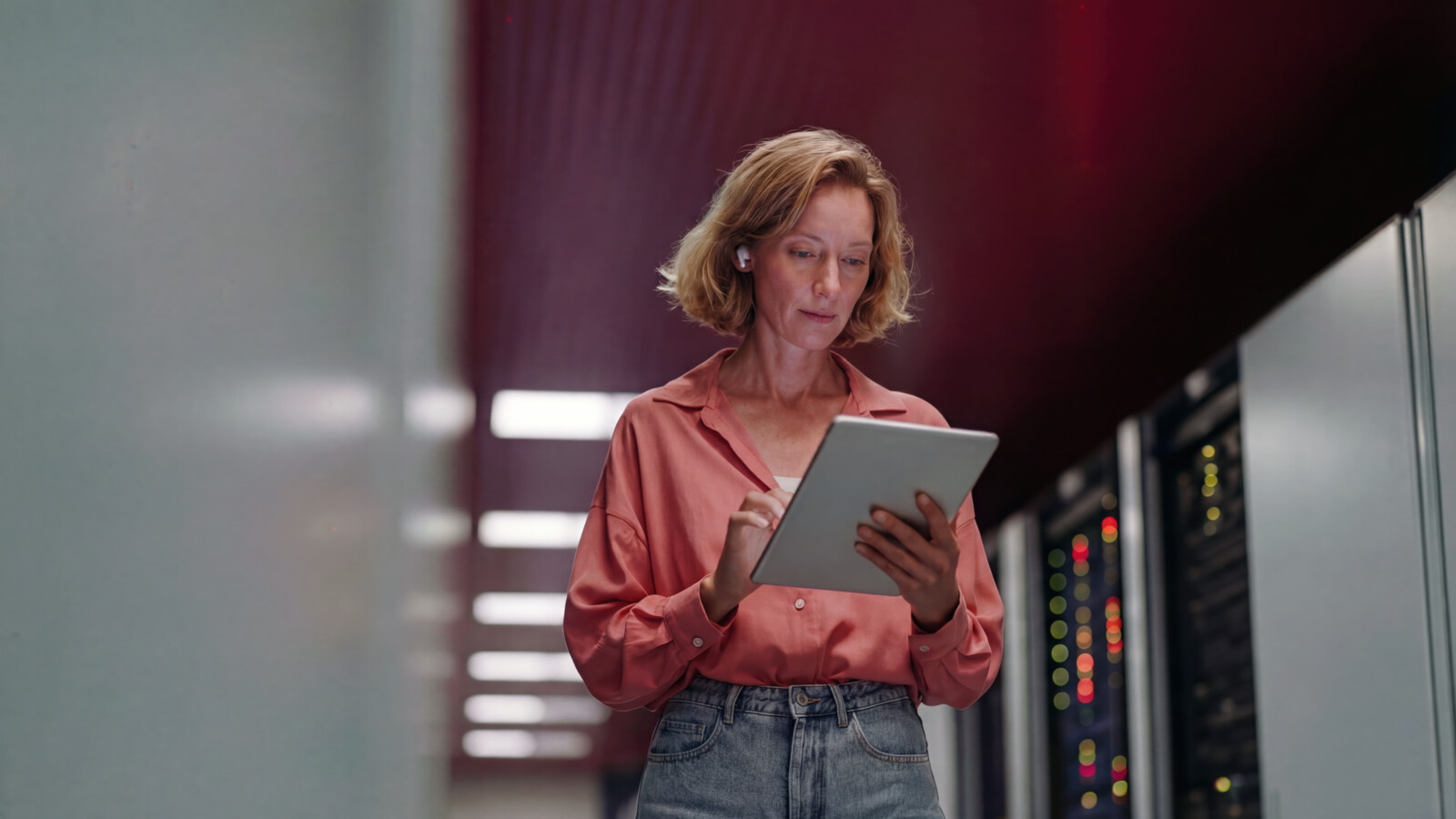 AI_generated Woman using tablet while standing in data center corridor