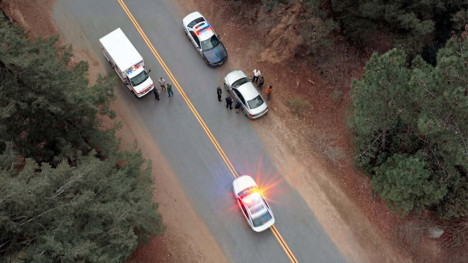 Police and emergency vehicles responding on rural road aerial view