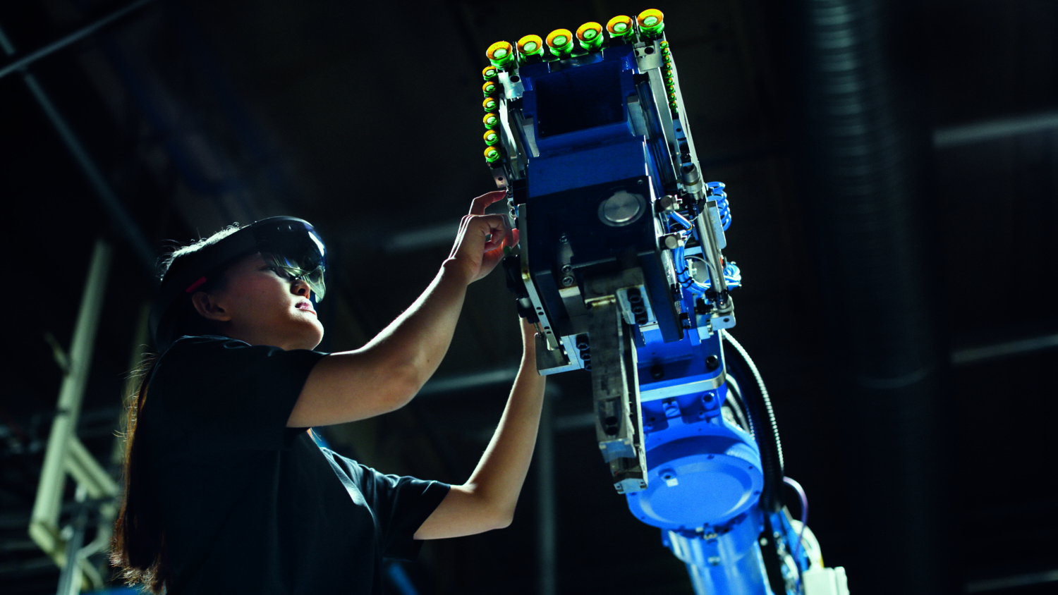 Woman interacting with factory robot.
