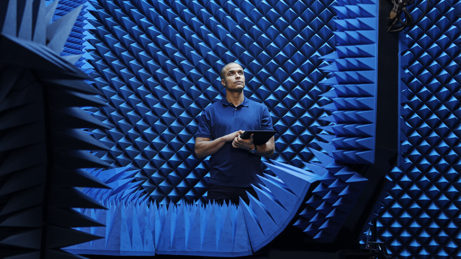 Engineer with tablet in test chamber.