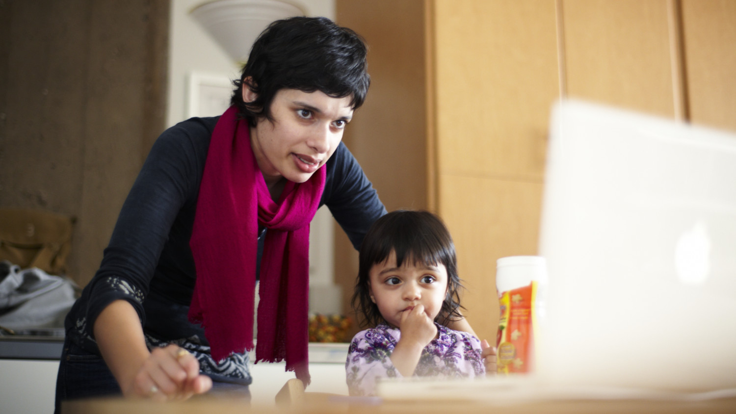 Uma jovem e sua mãe trabalhando em um computador.