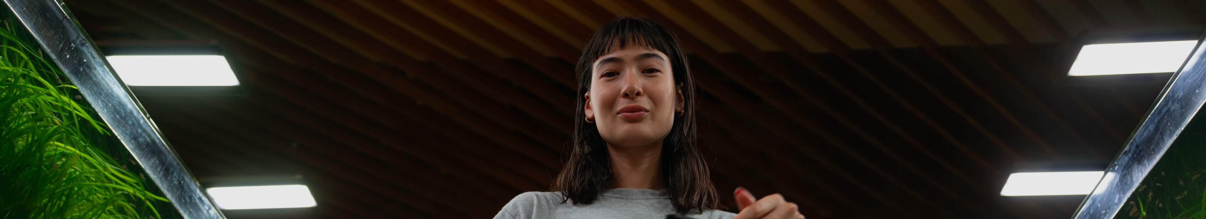 Two people jogging by lake at sunrise, city skyline behind.
