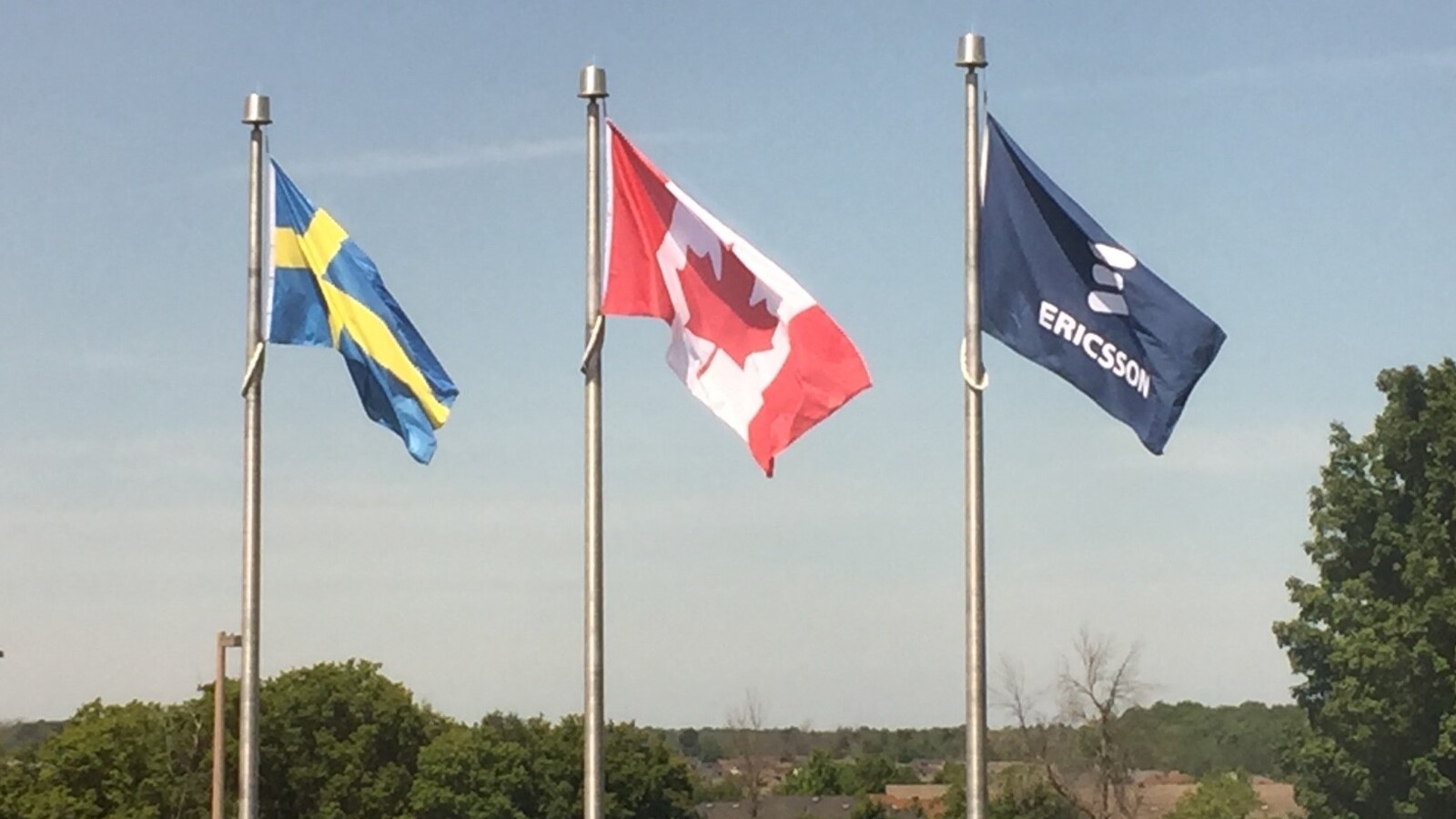 Swedish, Canadian and Ericsson flags fly side by side.