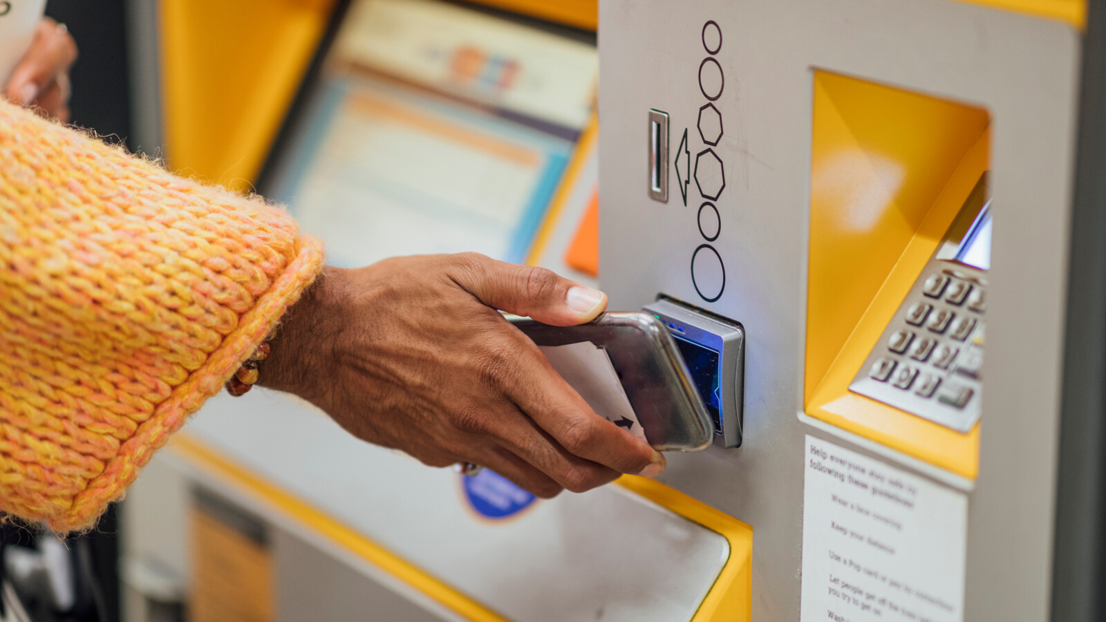 Person pays with phone at an ATM