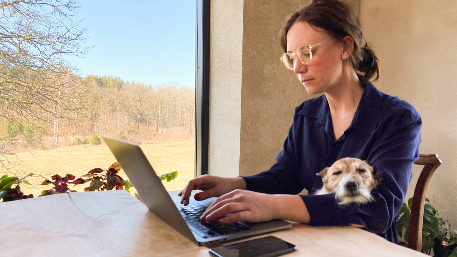 Woman working from home with dog in lap with the use of 5G SASE
