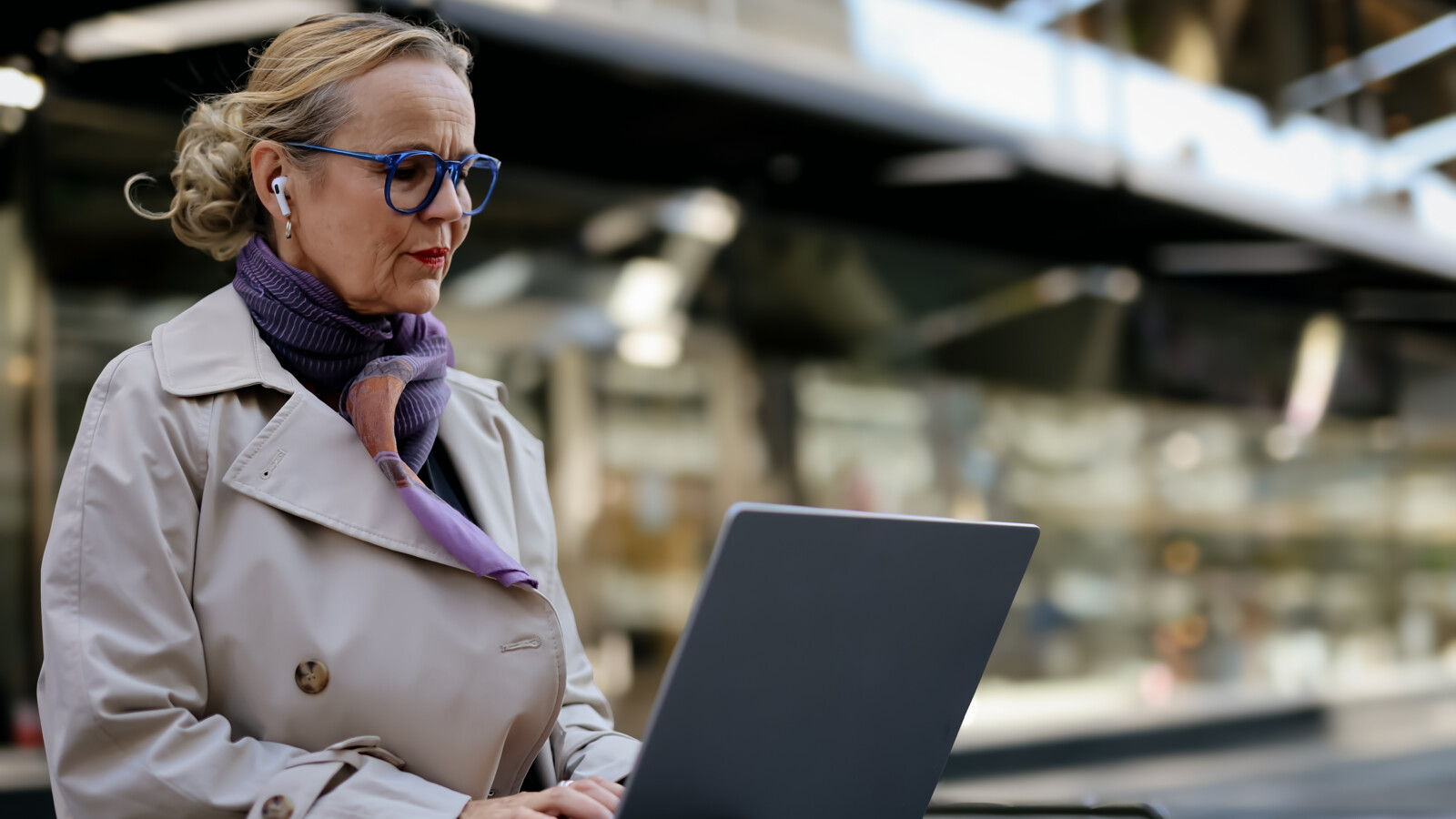 Woman working on her laptop at a train station