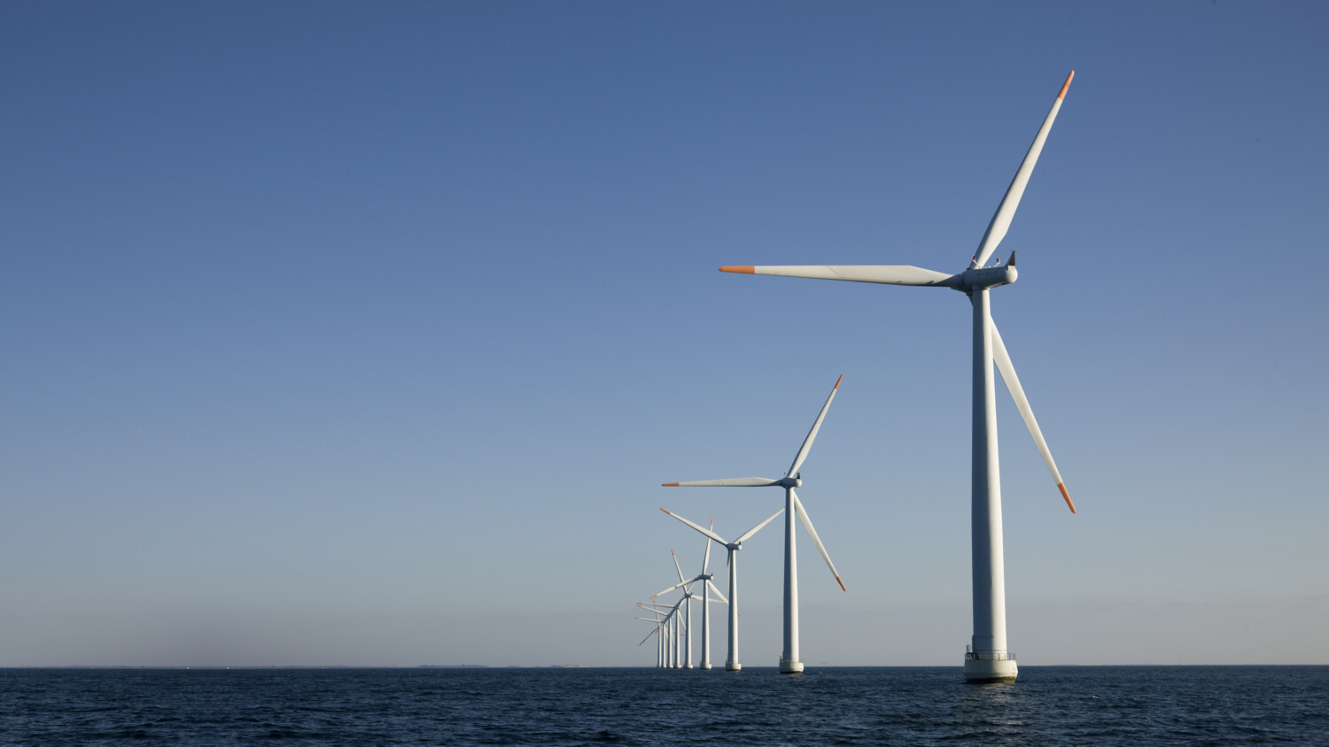 Offshore wind turbines in calm ocean.