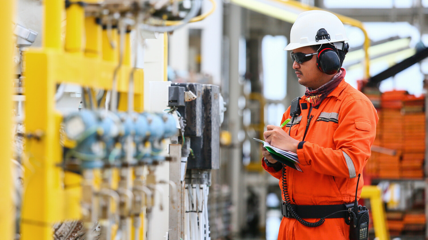 Industry worker monitoring an automated manufacturing facility.