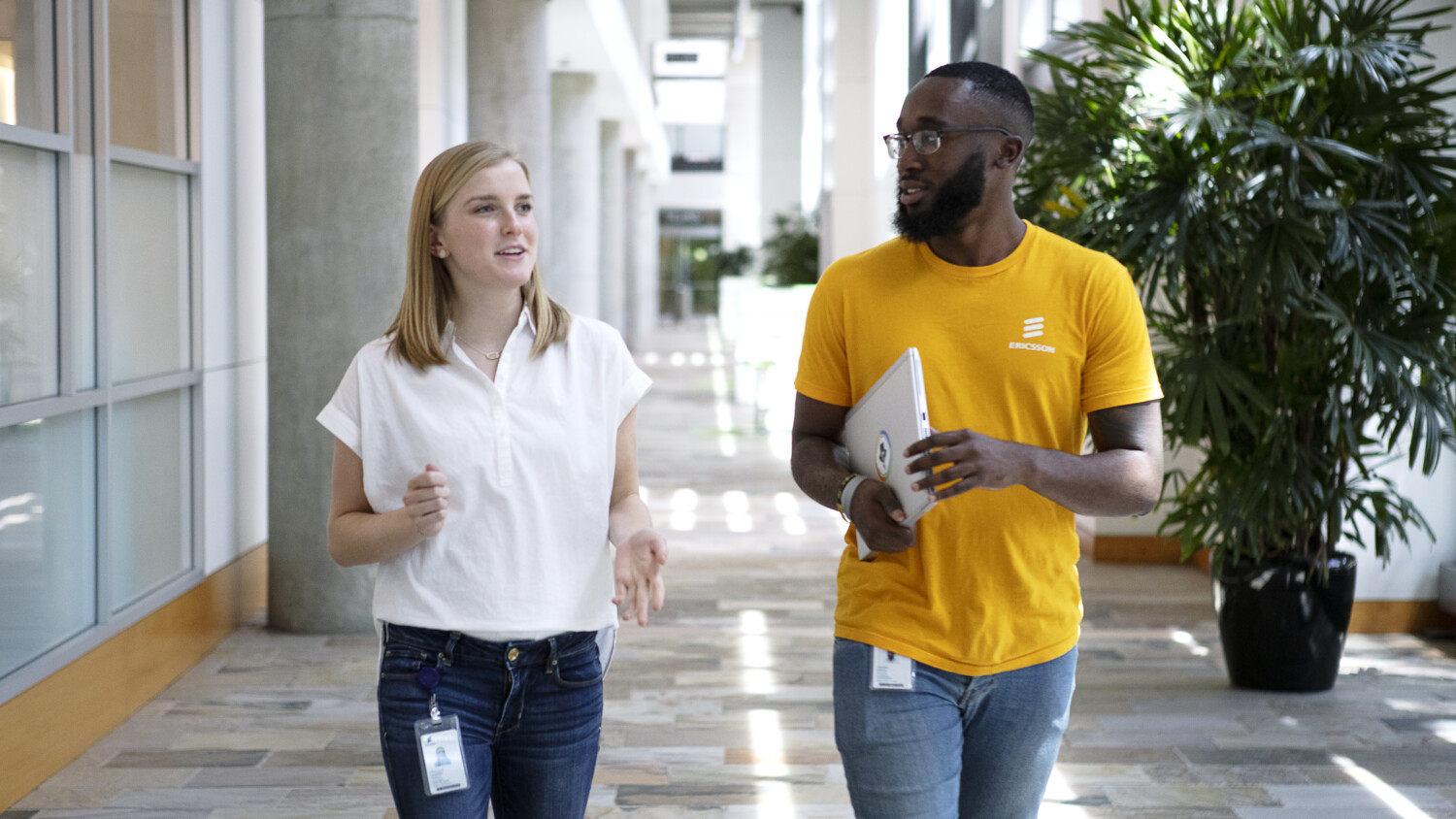 Two colleagues walking in a corridor and talking to each other