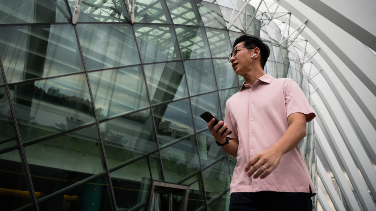 Man walking outside office with phone.