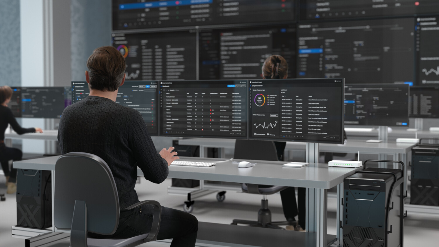 Man in front of screens in a room monitoring security.