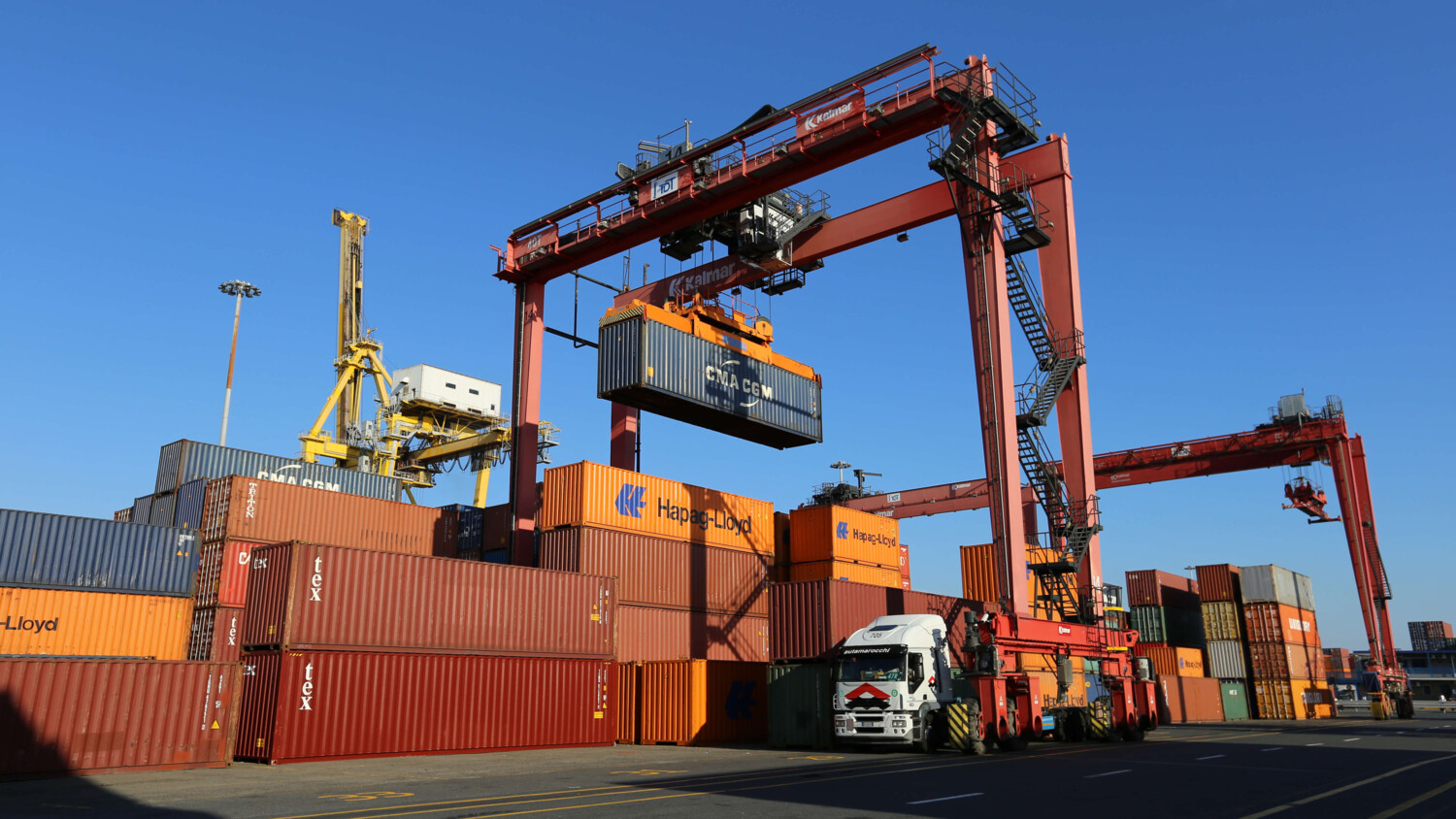 Connected cranes lifting containers at a smart port