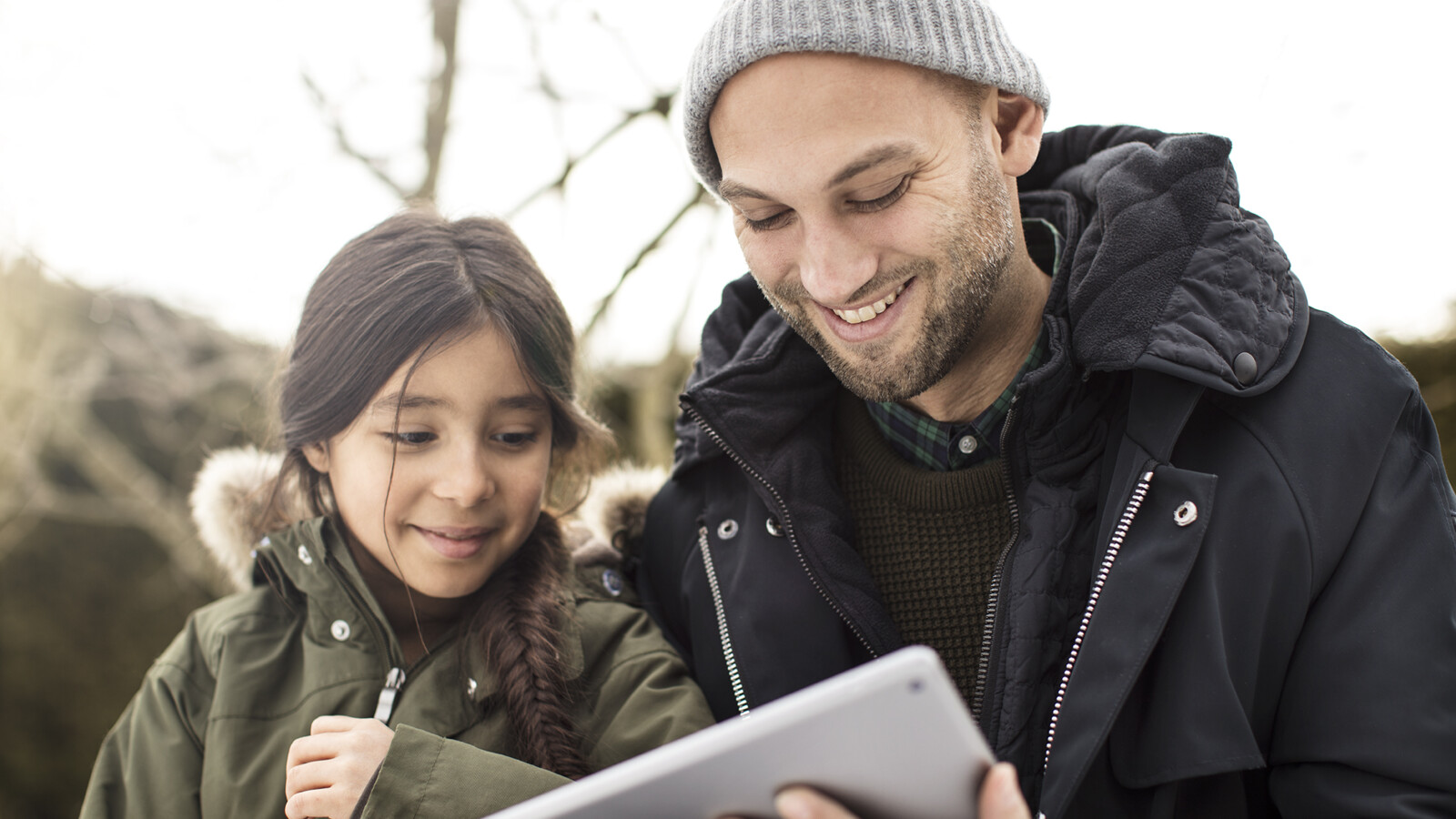 Father and daughter playing on iPad