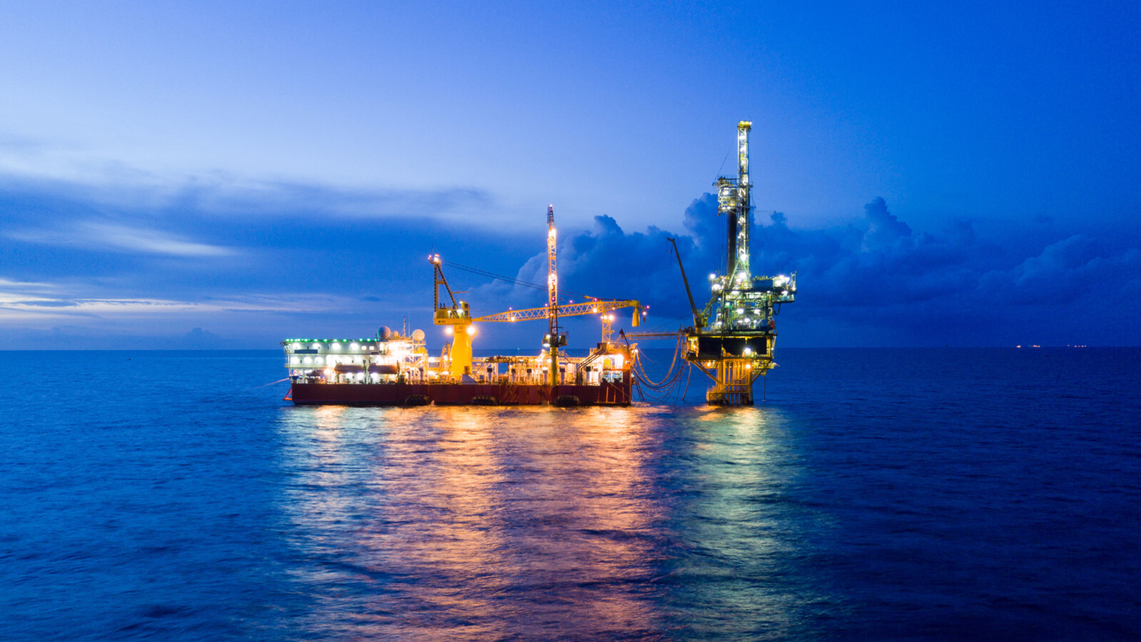 Offshore oil platform at night with lights.