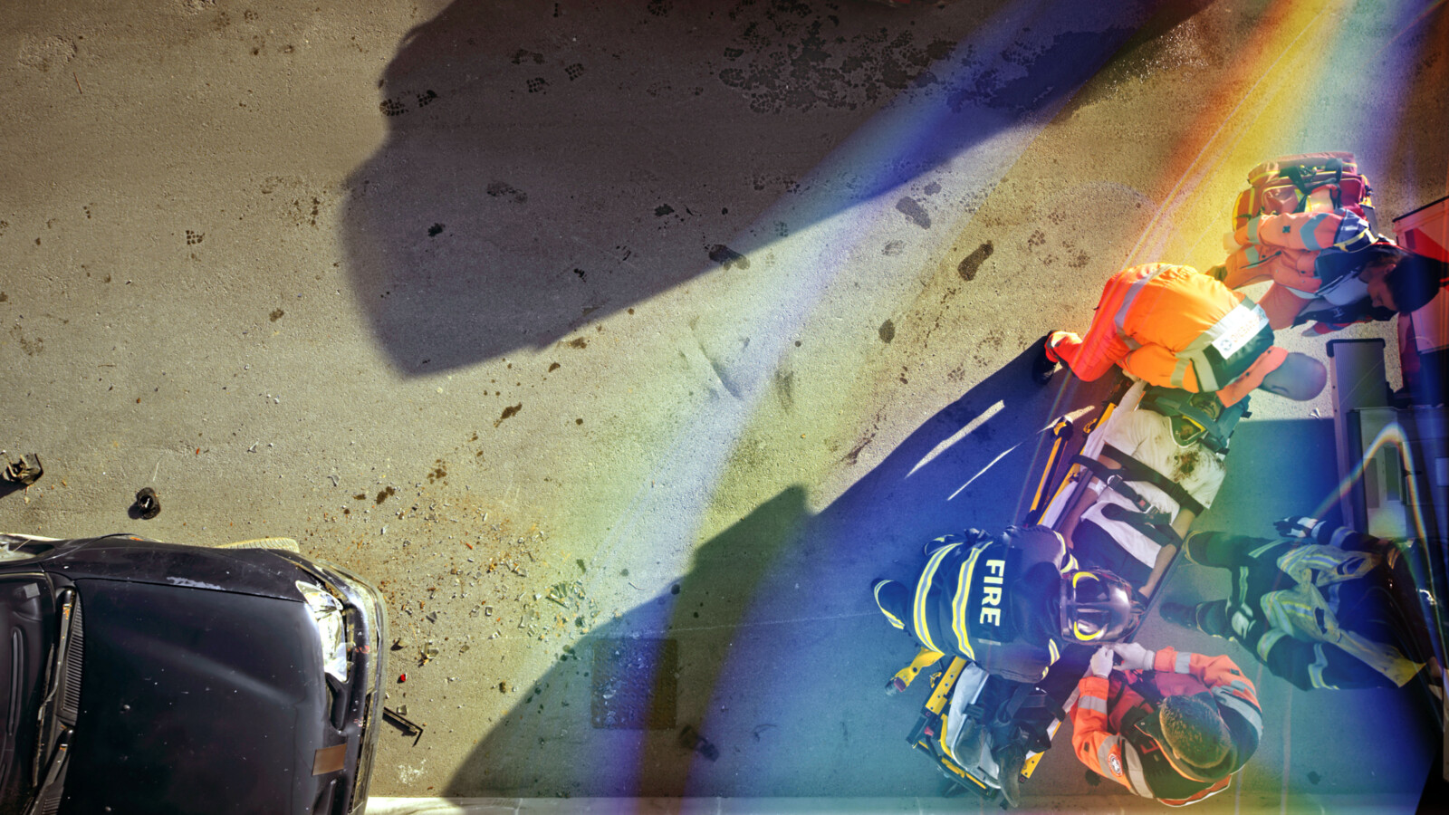 Firemen and medical staff attending person in the street.