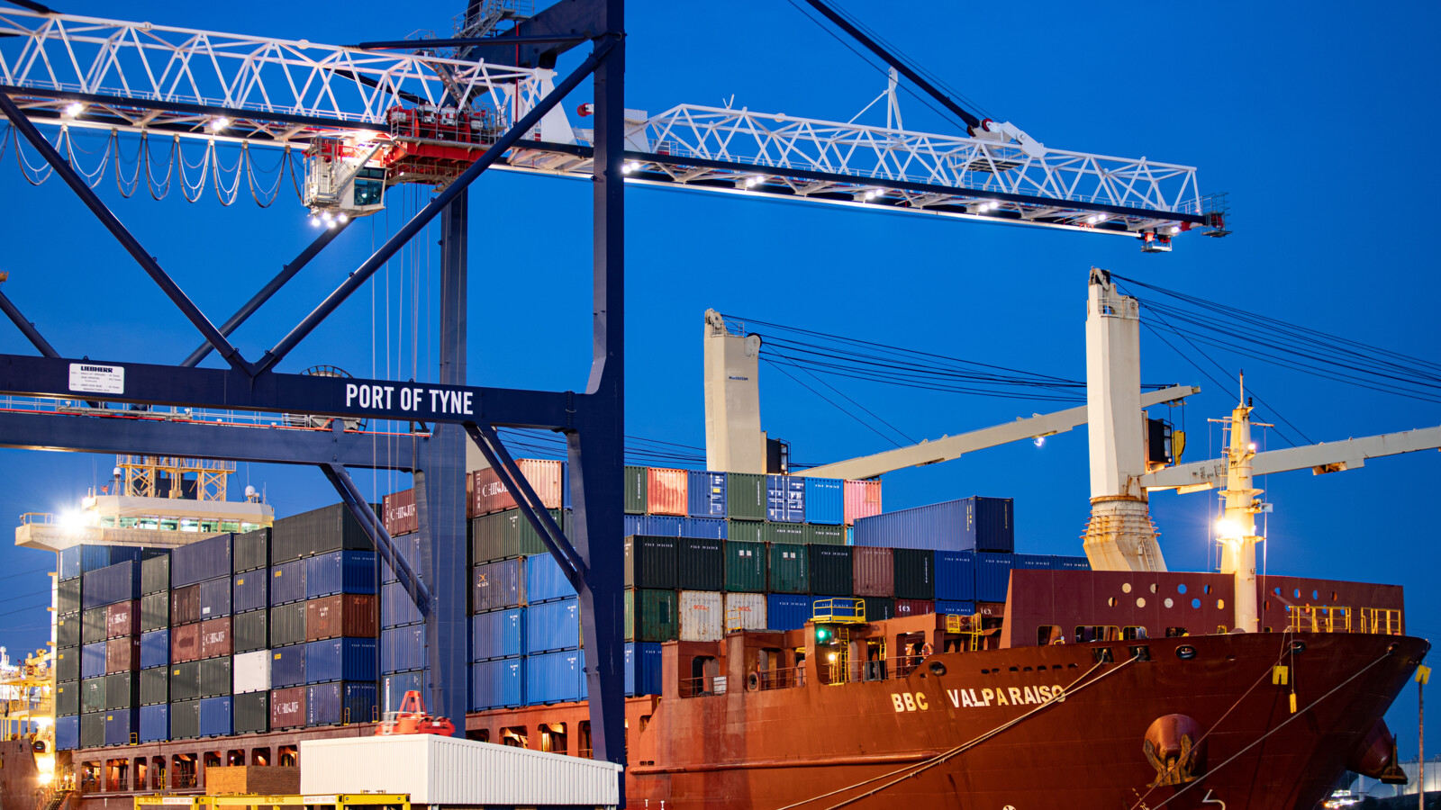 Crane at a port beside a container ship.