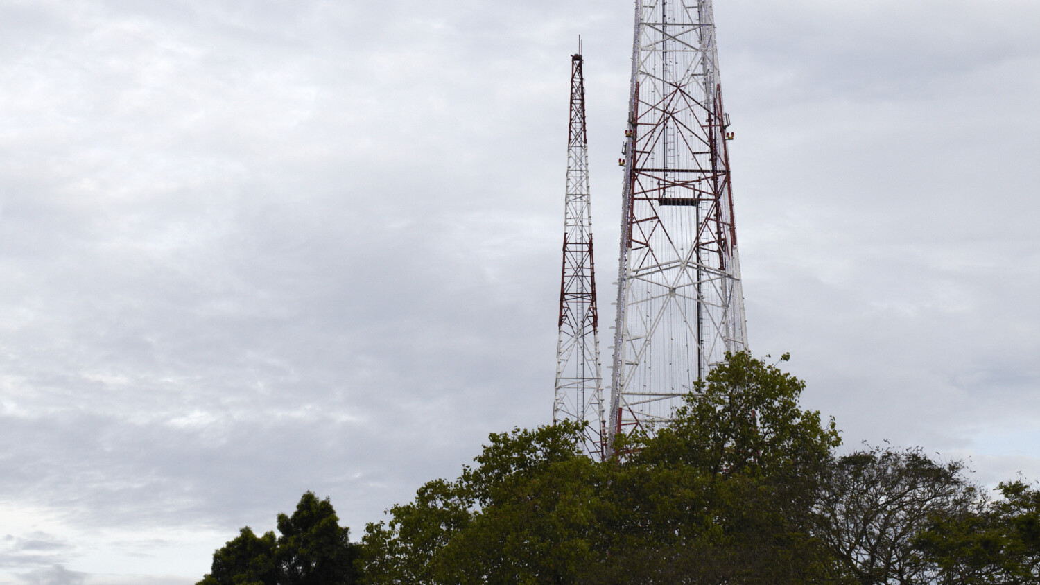 Tall power tower in green landscape.
