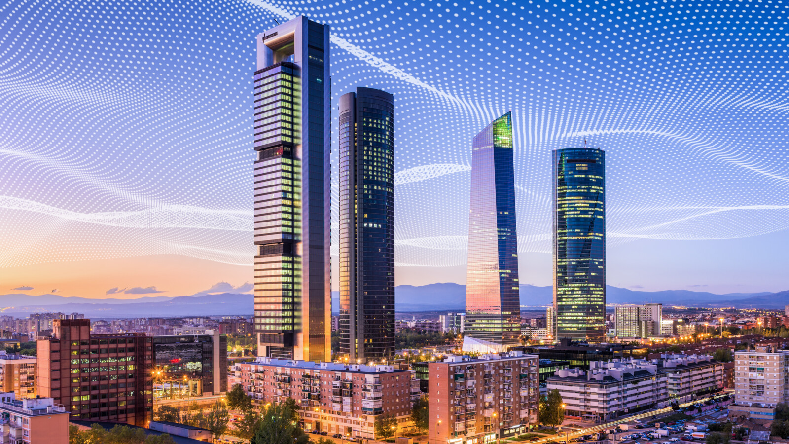 City skyline at sunset with dotted network lines in sky.