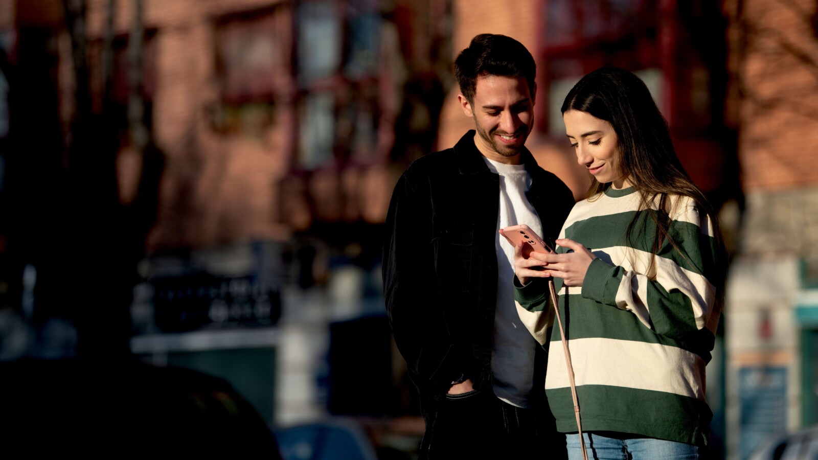 Two people looking at a smartphone.