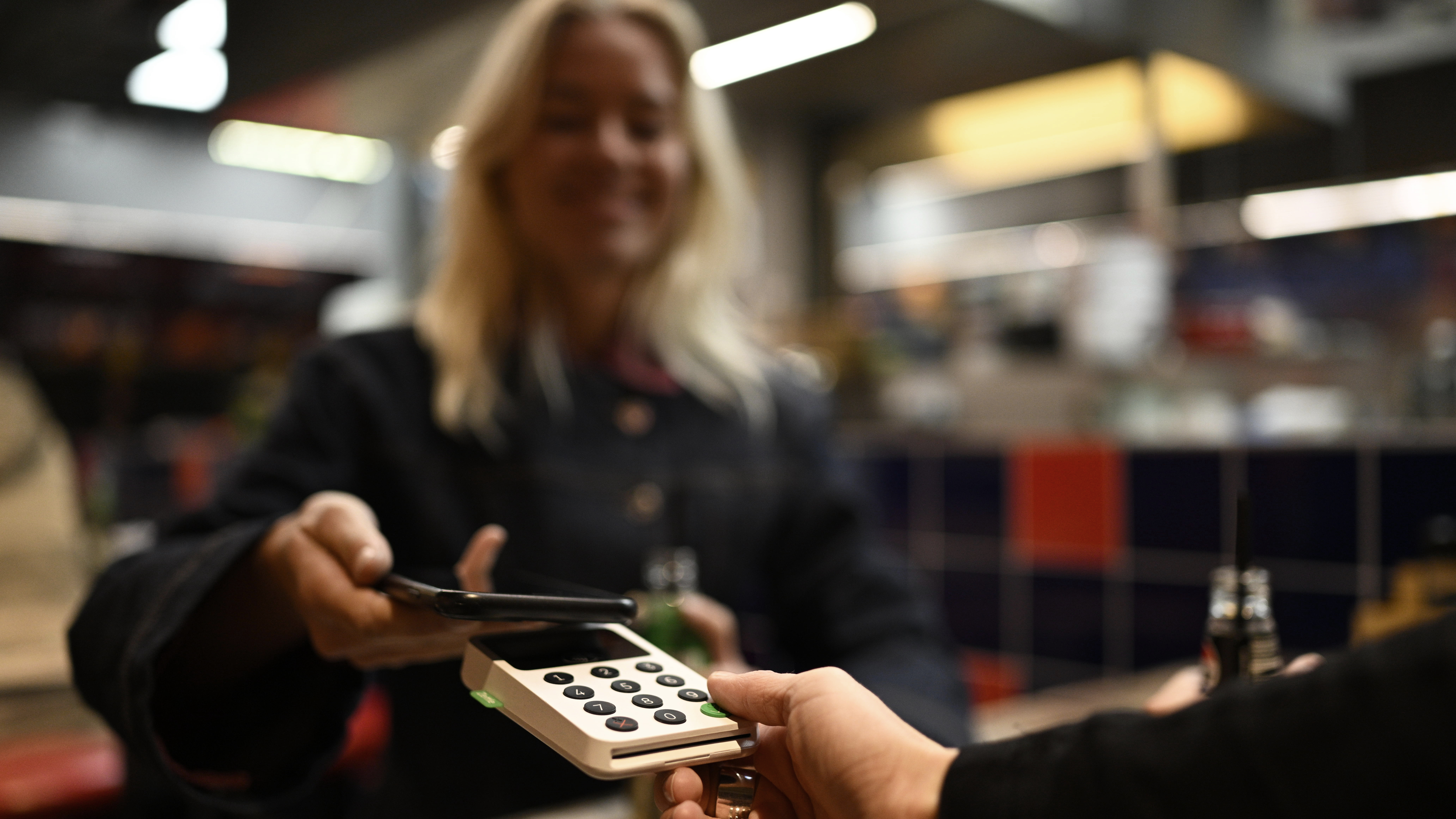 Female customer making mobile payment at shopping mall