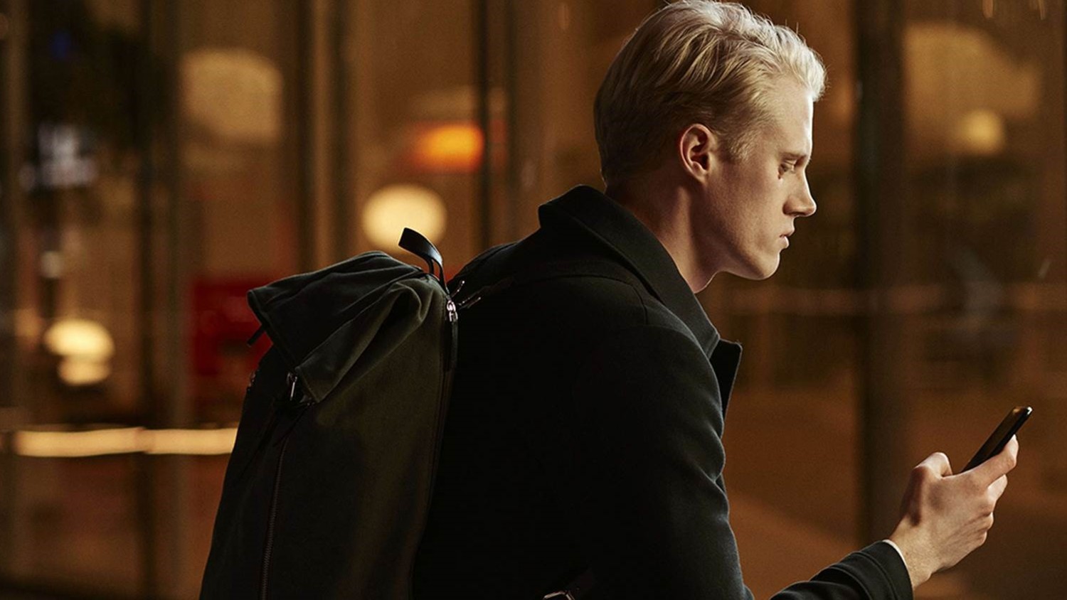 Man checks social media on smartphone while walking in the street