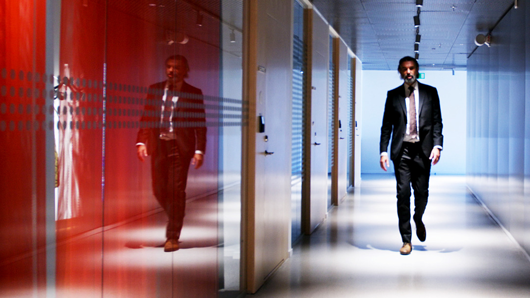 Man walking in colorful office corridor.