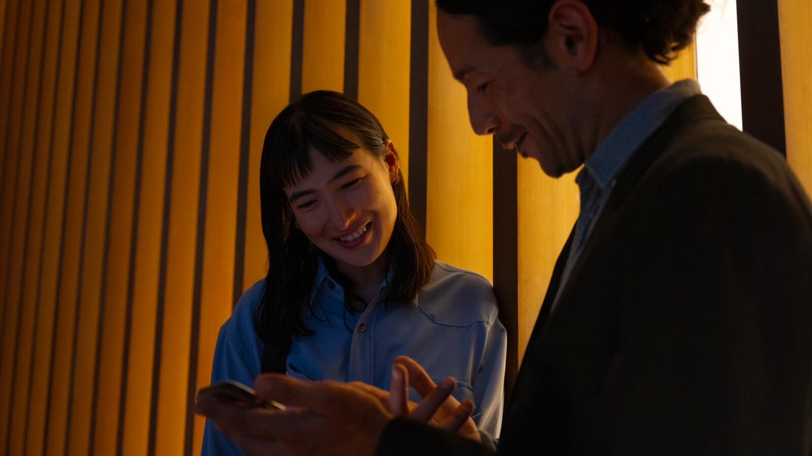 A man showing a woman something on the phone