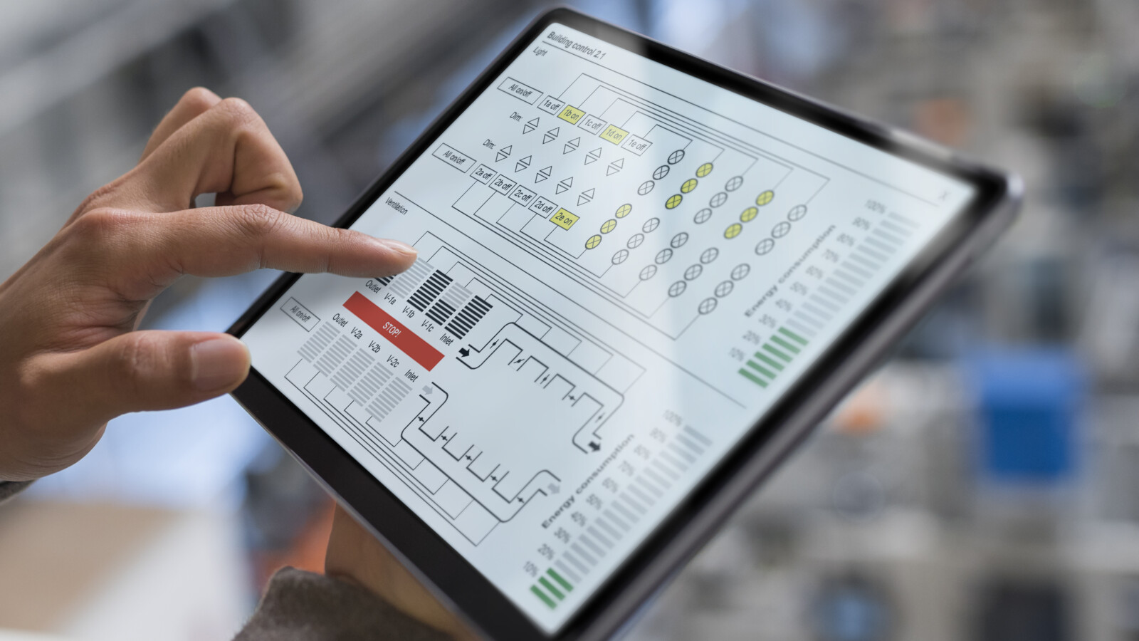 A woman working on a 5G-connected tablet overlooking a factory floor.