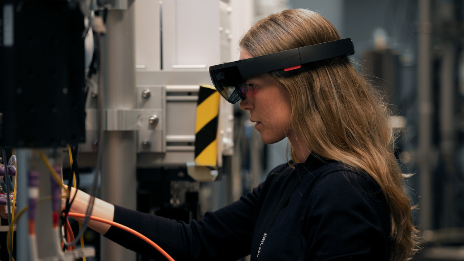 Engineer inspecting rack with AR glasses.