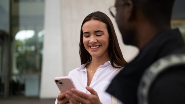 A woman smiling holding phone