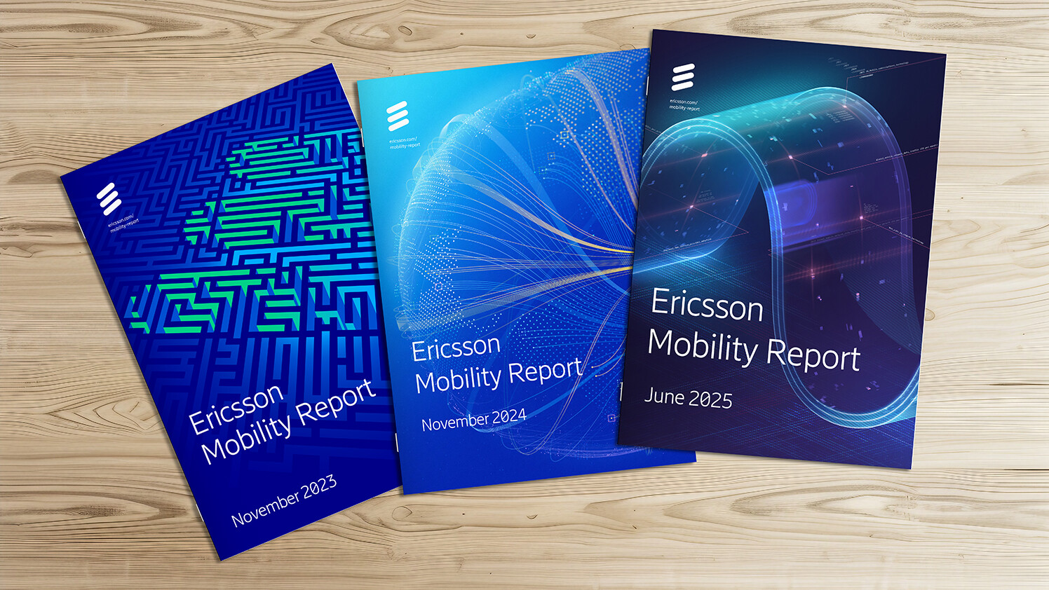 Three printed versions of past Ericsson Mobility Reports.