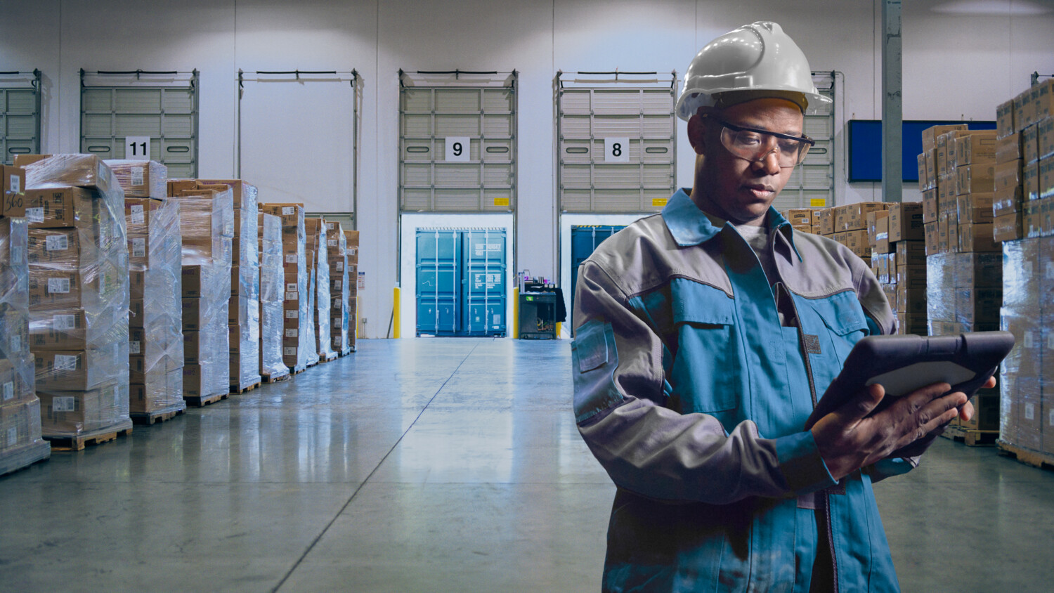 Man with IoT device in warehouse loading dock.