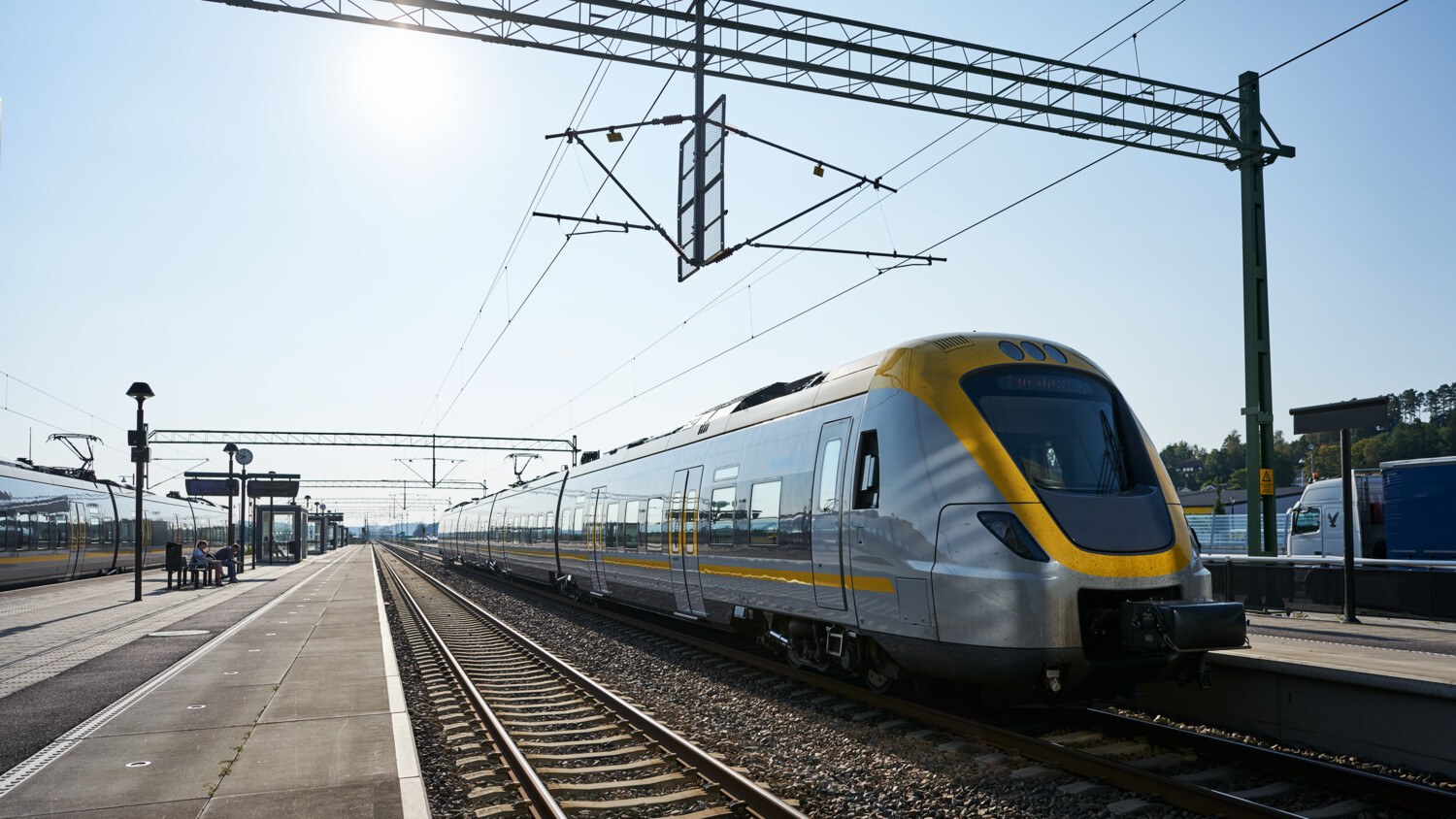 Modern train at a railway station under clear sky.