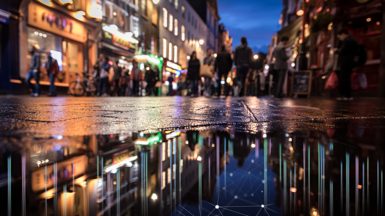 City street at night with lights reflecting on wet road.