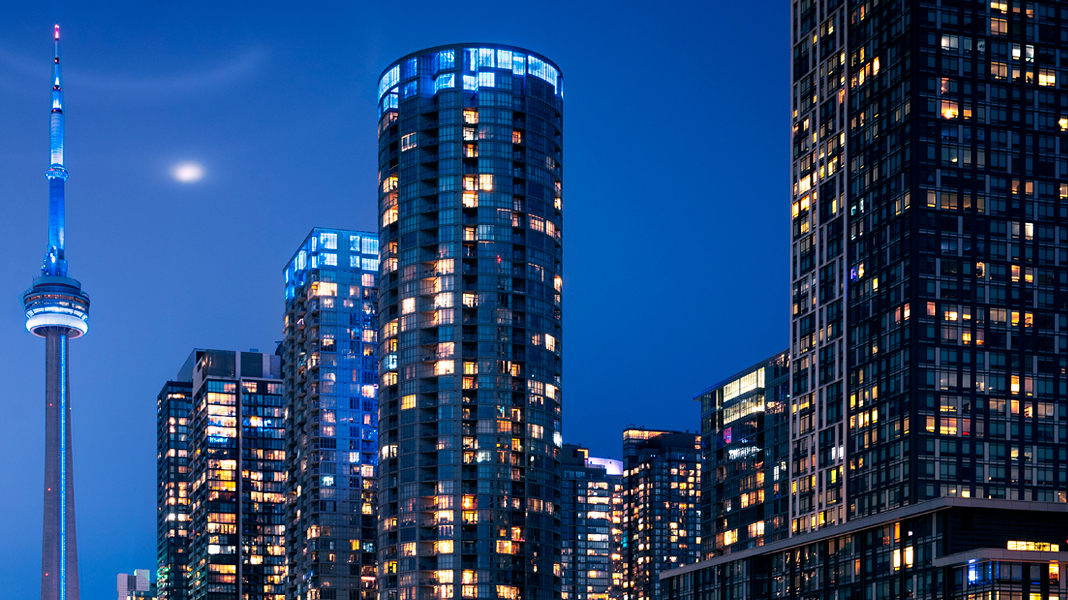 Night cityscape with a telecommunications and observation tower and lit high-rise buildings.