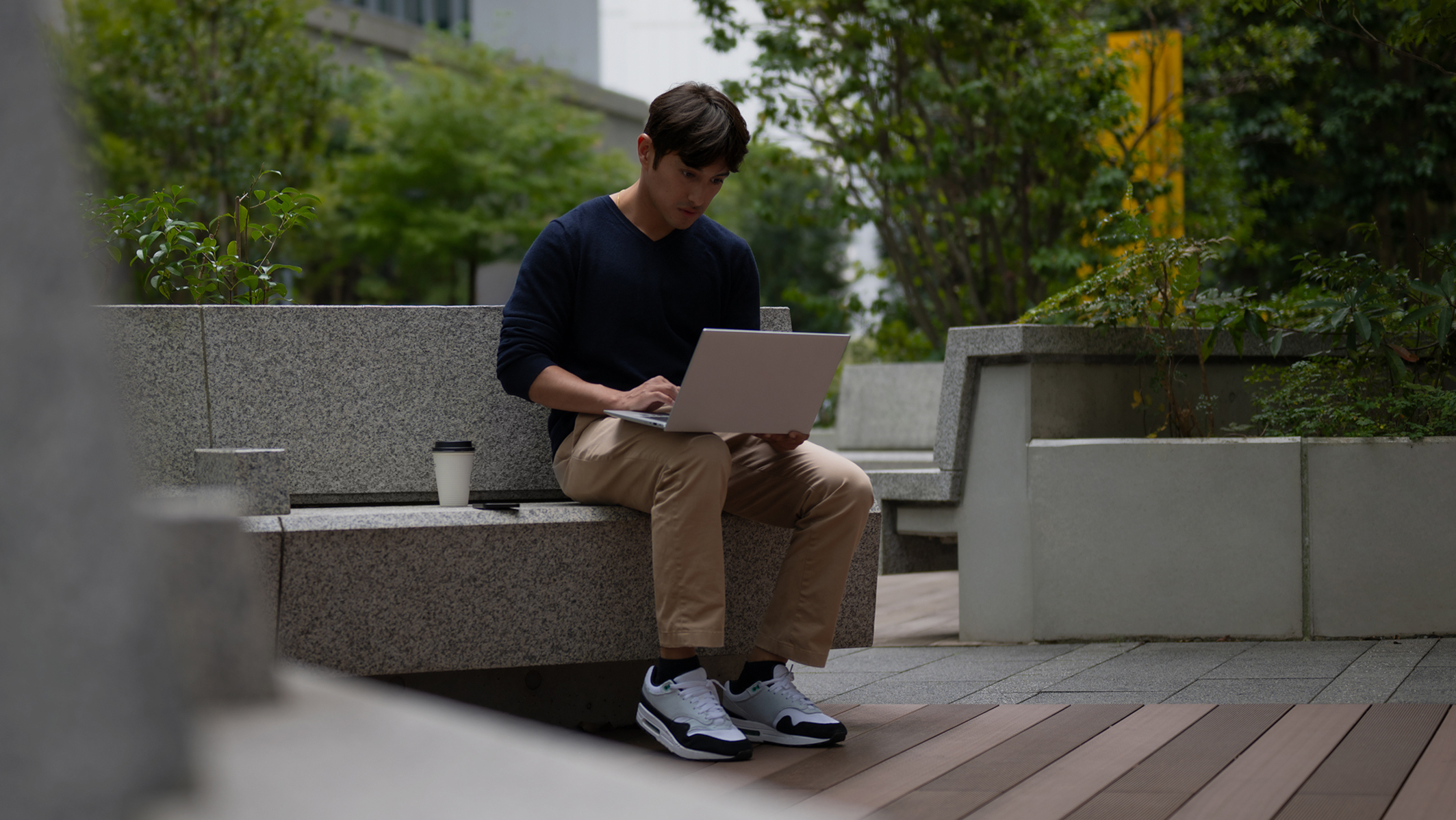 Man working on his laptop in the courtyard.