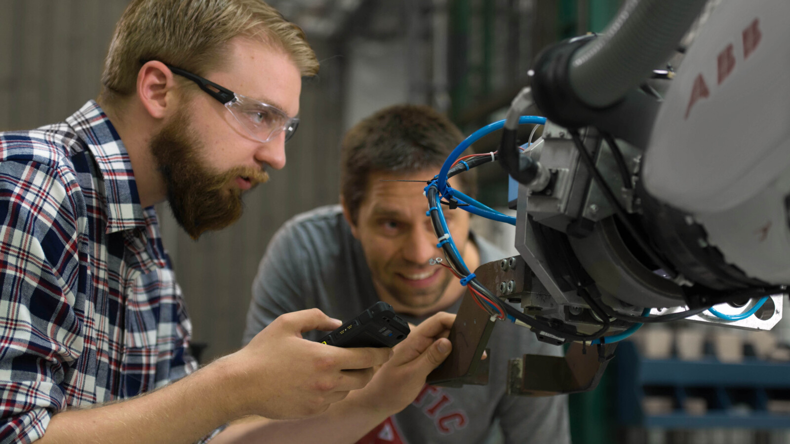 Technician working with IoT prototype robot in a connected factory.
