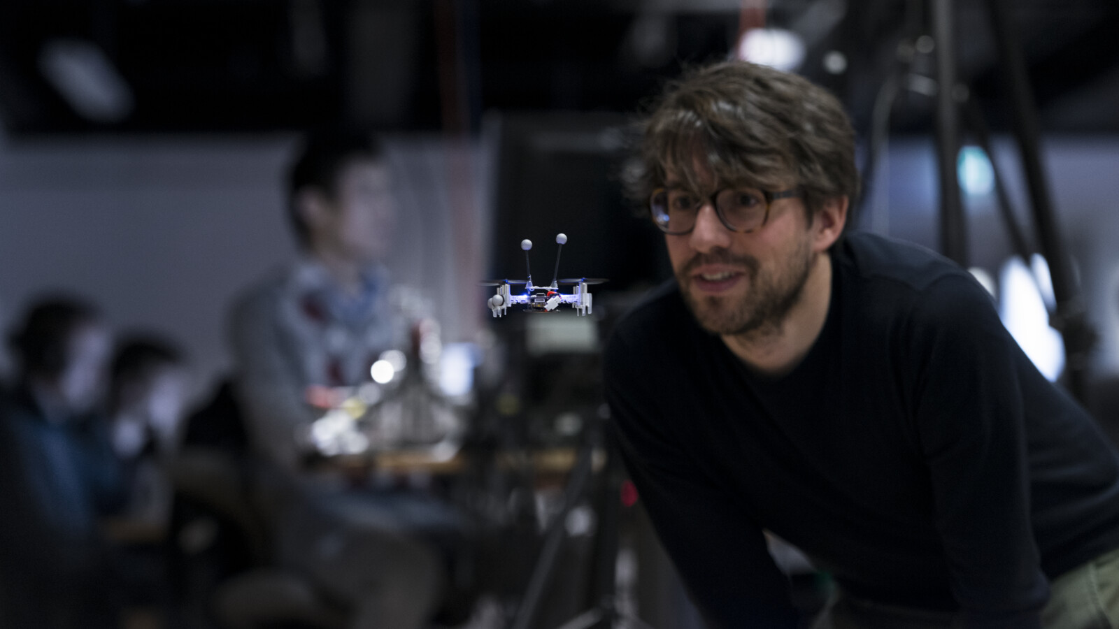 A man looking at a small drone.