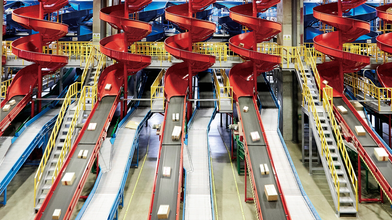 Packages move on belts and chutes in sorting facility.