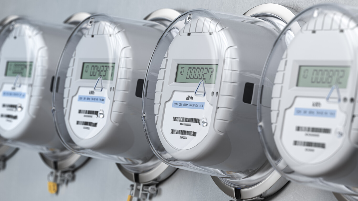 Four digital electric meters on a wall.