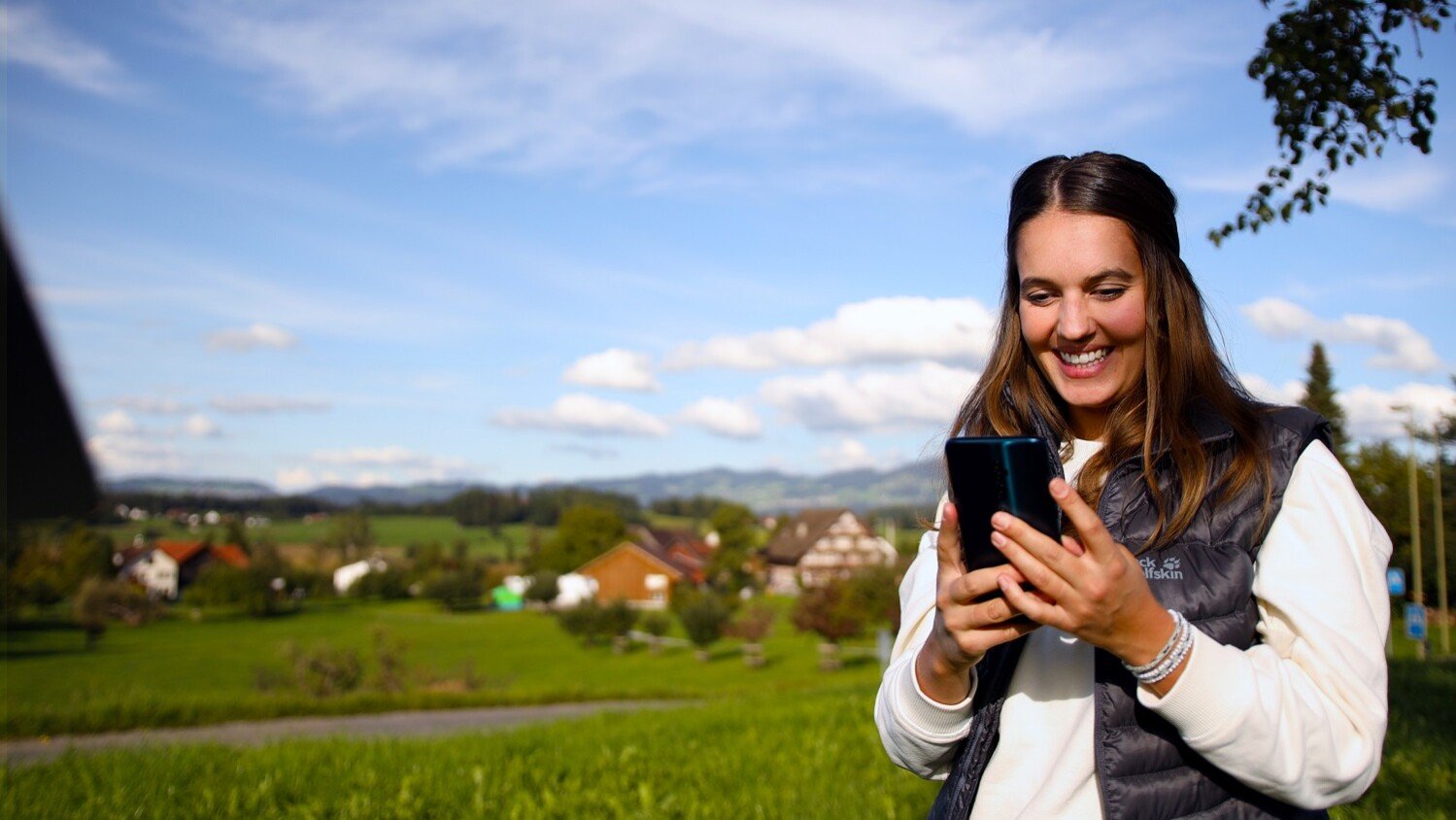 Woman using her phone in a rural area.